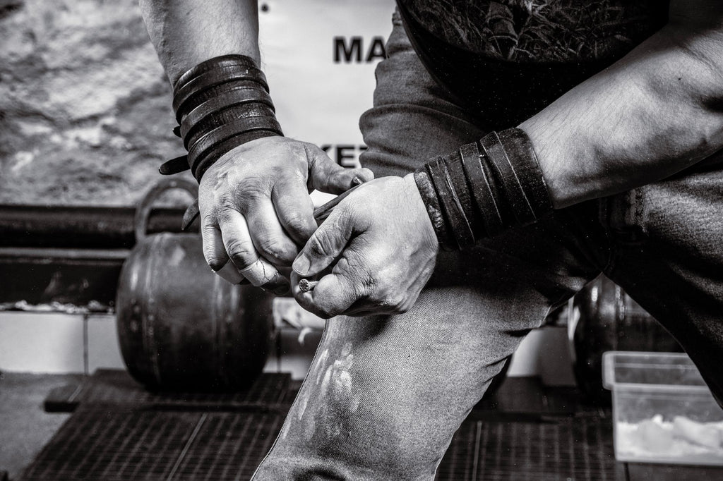 Atleta usando straps de levantamiento en el gimnasio