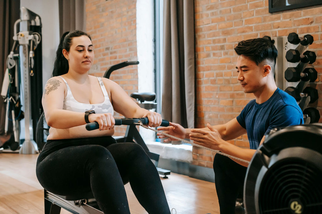 Persona entrenando remo en máquina en el gimnasio