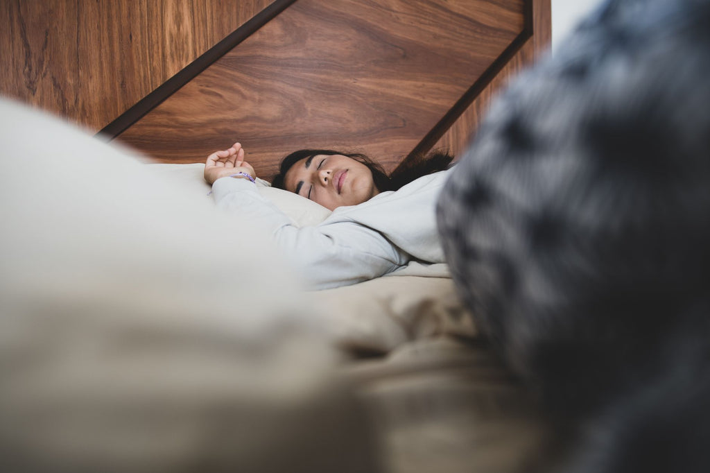Persona durmiendo con el brazo flexionado bajo la almohada